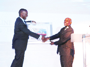 Kennedy Hamutenya, Namibia’s diamond commissioner, hands over a map which illustrates Debmarine Namibia’s mining areas to Prime Minister, Nahas Angula at the launch of the company‘s logo and identity.