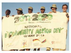 Enthusiastic participants of the National Biodiversity Action Day seen here on top of a dune with the official banner. (Photograph by Hilma Hashange)