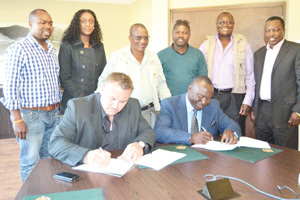 Wessie van der Westhuizen (Managing Director of Namibia Breweries Limited) and Andreas Nuule (President of Namibia Retailing Traders Association (NRTA) signing the Memorandum of Understanding agreement while James Maswahu (NBL); Jessica Gabriel (NBL); Onesmus Iiyambo (NRTA); Simon Iipinge (NRTA); Michael Ndivaele (NRTA); and Gideon Shilongo (Ohlthaver & List Group of Companies) look on.
