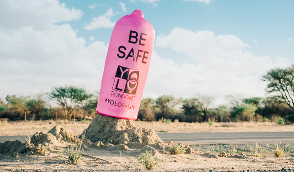 Giant condoms on termite mounds spread the Be Safe message.